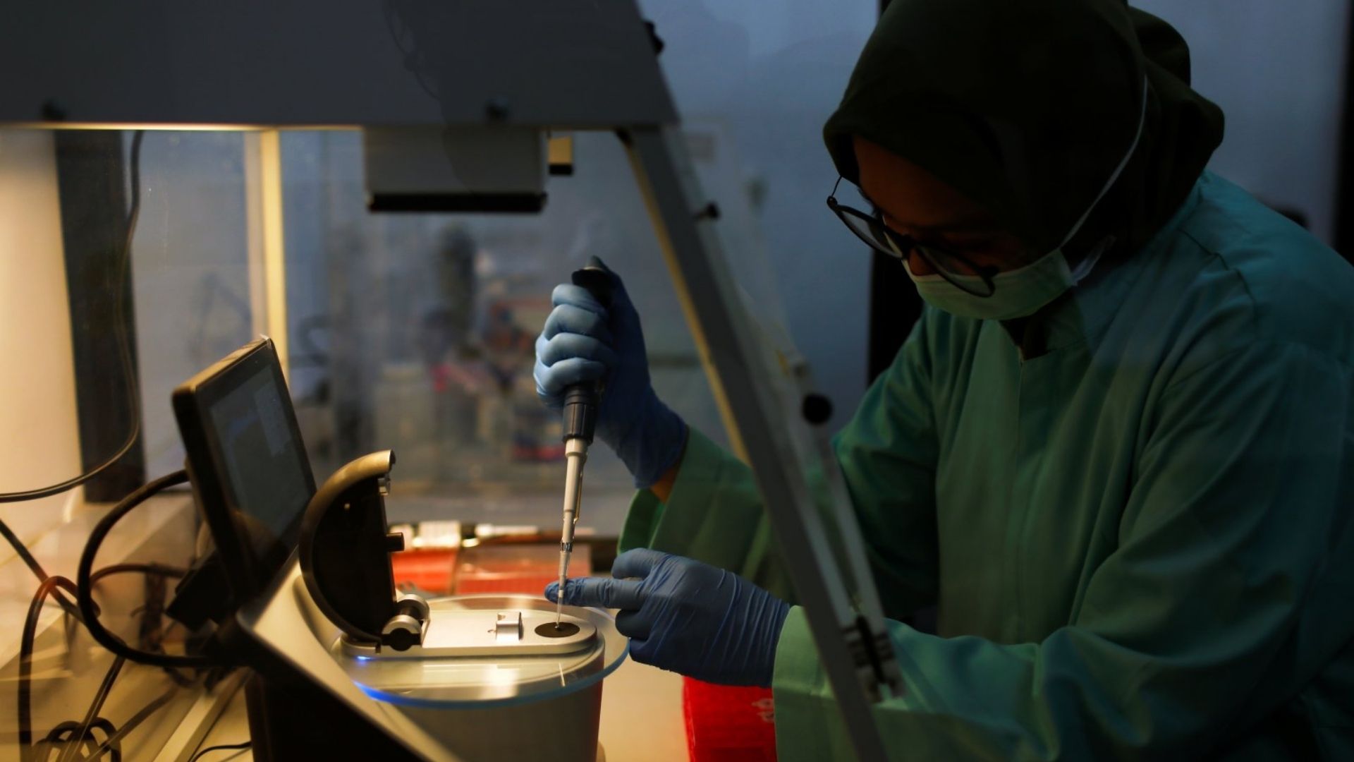 Profissional em laboratório farmacêutico realizando testes de controle de qualidade com equipamento de precisão, representando os rigorosos processos de certificação halal para produtos de saúde.